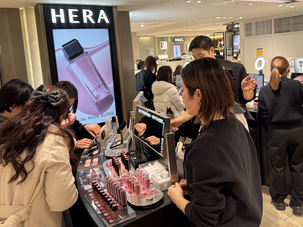 팝업 행사에서 고객들이 립 제품과 베이스 메이크업 제품을 체험하고 있다. [중앙포토]