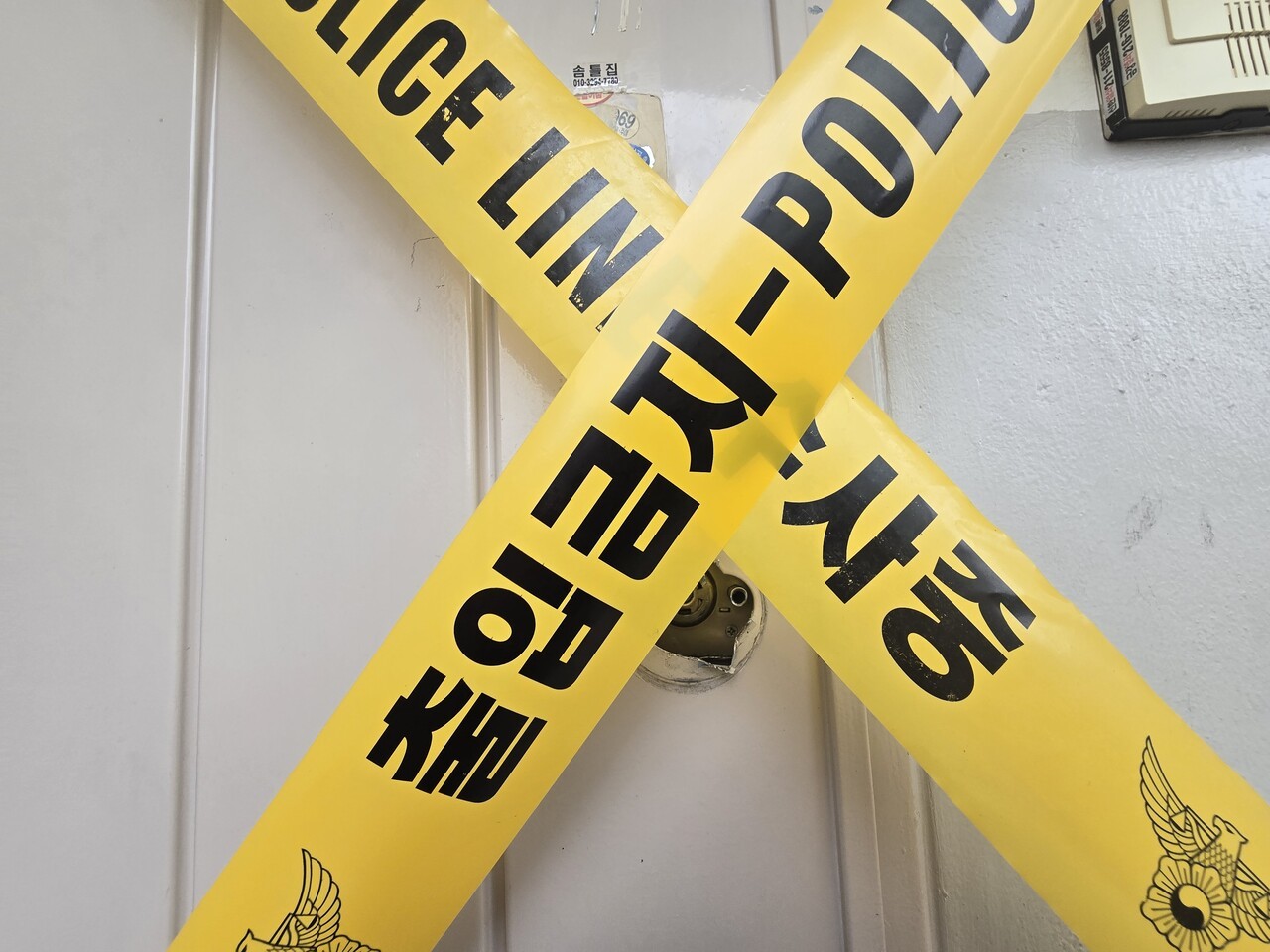지난 4월 21일 오후 모녀가 숨진 채 발견된 경기 수원 권선구 아파트 현관에 경찰 출입금지 폴리스라인이 쳐져 있다. 현관 밖엔 모녀가 사용하던 것으로 추정되는 바퀴 달린 장바구니와 금융결제원에서 발송한 우체국 등기, 파손된 현관 문고리 등이 놓여있었다. 손성배 기자