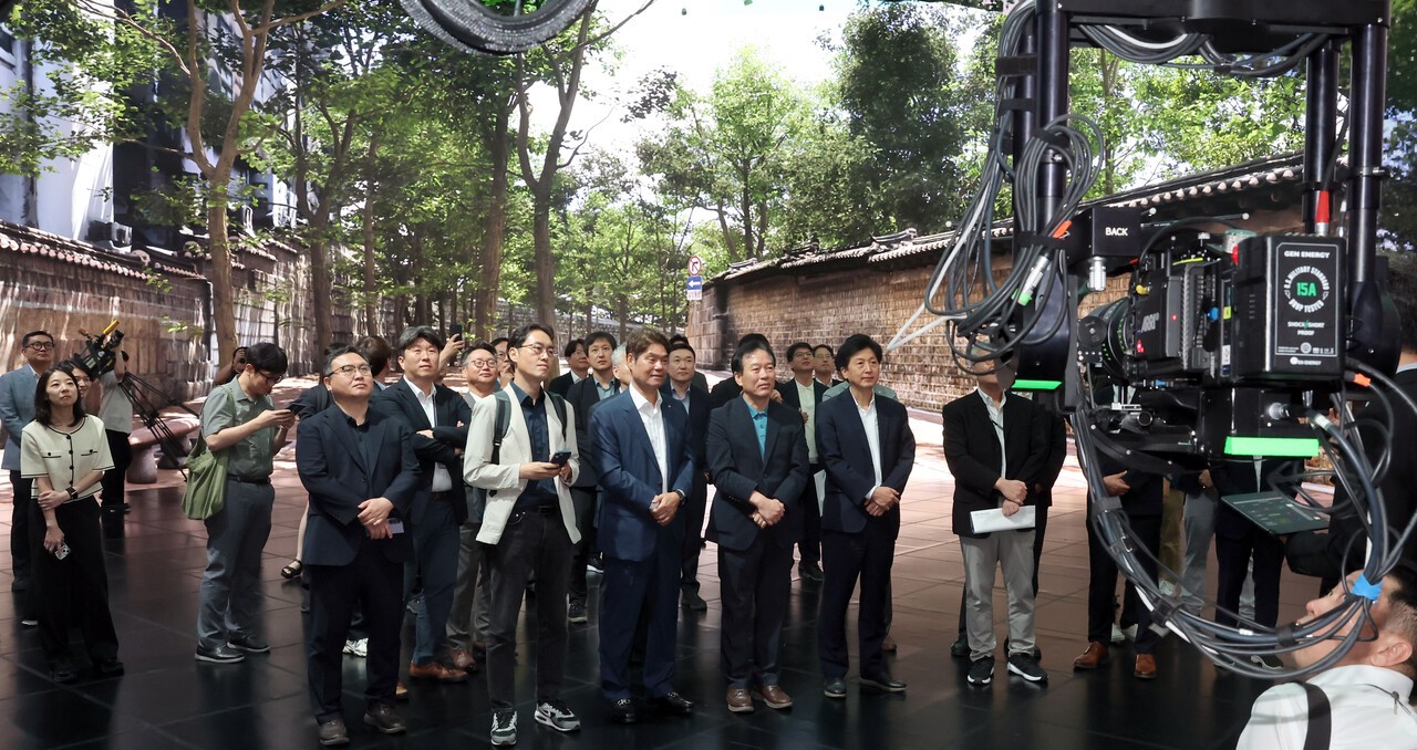 2025년 7월 30일 정부 국정기획위원회 인사들이 경기도 파주시 CJ ENM 스튜디오 센터를 방문해 CJ 관계자들의 설명을 듣고 있다. 이들의 배경은 최첨단 디스플레이로 구현된 스크린이다. [연합뉴스]