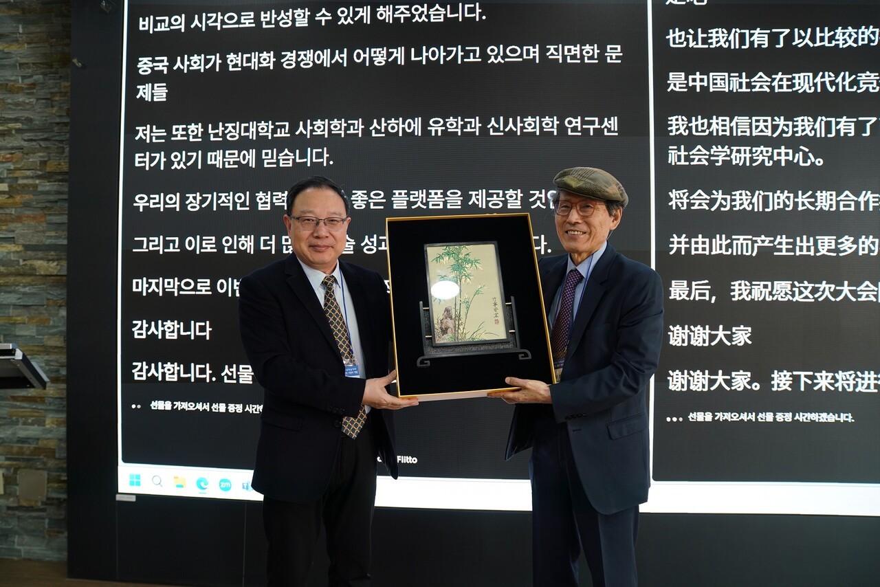 난징대 유학과신사회학연구소는 서울대 사회발전연구소와 학문적 교류협력(MOU)을 체결했다. 사진은 난징대 쳉보칭 교수(왼쪽)와 한상진 서울대 명예교수가 선물을 주고받는 모습으로, 한상진 교수는 난징대 겸임교수, 유학과신사회학연구소장을 겸하고 있다. [사진 중민재단]