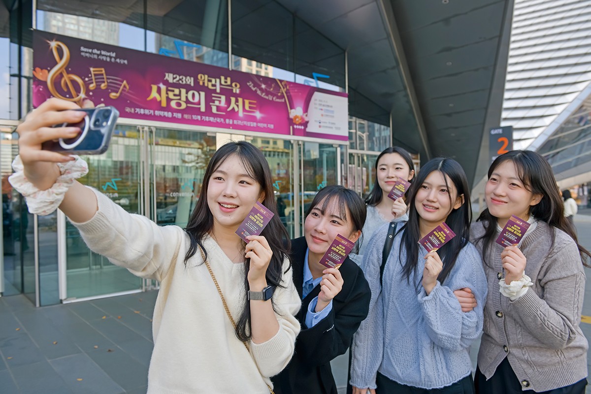 위러브유 회원들이 콘서트 입장권을 들고 기념사진을 찍고 있다. [사진 국제위러브유운동본부]